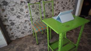 einen grünen Schreibtisch und einen Stuhl mit Laptop in der Unterkunft SPOT ON 92860 Hunian 99 in Banyuwangi
