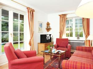 a living room with red chairs and a tv at Enenhoog-Flugente in Kampen