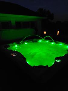 a green hot tub with lights in the dark at 4BR Home - Pool, hot tub pet friendly by ARK Experience in Williamstown +10 photos