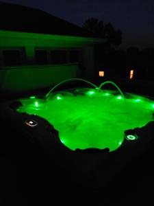 a green hot tub with lights in the dark at 4BR Home - Pets Allowed by ARK Experience in Williamstown