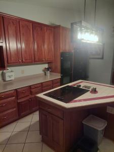 cocina con armarios de madera y nevera negra en 4BR Home - Pets Allowed by ARK Experience en Williamstown