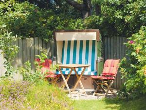 a picnic table and two chairs in a backyard at Enenhoog-Strandlaeufer in Kampen