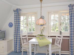 a dining room with a table and chairs and windows at Enenhoog-Strandlaeufer in Kampen