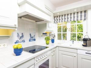 a white kitchen with white cabinets and a sink at Kojenhof-2 in Kampen