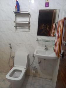 a white bathroom with a toilet and a sink at Entire 4 Bedroom villa in Trivandrum