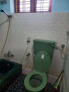 a bathroom with a green toilet and a bath tub at Entire 4 Bedroom villa in Trivandrum