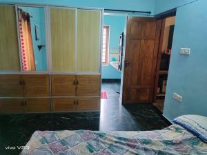 a bedroom with a bed and a wooden cabinet at Entire 4 Bedroom villa in Trivandrum