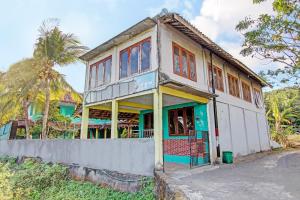 una casa vieja con una puerta verde en una calle en SPOT ON 92873 Losmen Parikesit, en Yogyakarta