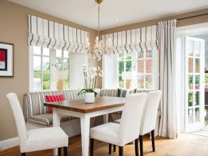 a dining room with a table and white chairs at Jolenhues in Kampen