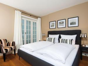 ein Schlafzimmer mit einem großen Bett mit weißer Bettwäsche und Kissen in der Unterkunft Jolenhüs in Kampen