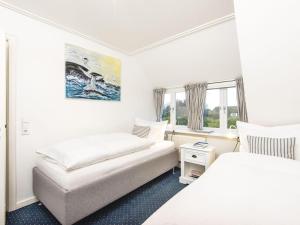 a white room with two beds and a window at Sonnenhof-F in Kampen
