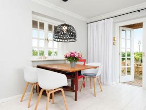 a dining room with a wooden table and white chairs at Kaeptn-Cook-4 in Kampen