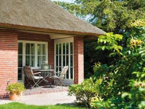 een stenen huis met een tafel en stoelen op een patio bij Min-Go in Kampen