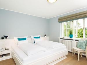 een wit bed in een kamer met een raam bij Min-Go in Kampen