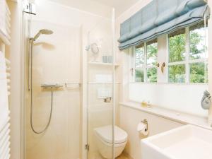 een badkamer met een douche, een toilet en een wastafel bij Min-Go in Kampen