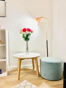 wazon kwiatów na stole obok lampy w obiekcie Scandinavian Apartment Hotel Fjordhavn - 2 room apartment w mieście Horsens