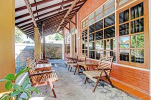 a group of wooden tables and chairs on a patio at OYO 92885 Satriafi 2 Hotel in Yogyakarta