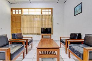 a room with chairs and a table and a tv at OYO 92885 Satriafi 2 Hotel in Yogyakarta