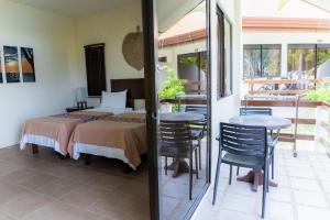 a bedroom with a bed and two tables and chairs at Kasagpan in Tagbilaran City