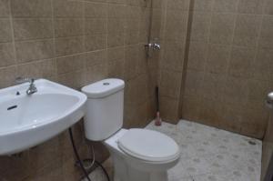 ein Bad mit einem WC und einem Waschbecken in der Unterkunft OYO 92880 Wisma Nusantara in Manado