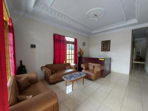 ein Wohnzimmer mit Sofas und einem Tisch in der Unterkunft OYO 92880 Wisma Nusantara in Manado
