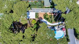 una vista sul parco con piscina e alberi di La Serena Hotel FDM a Forte dei Marmi