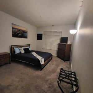 a bedroom with a bed and a dresser and a lamp at Stylish and Spacious, close to the Hospital. in Fort Wayne