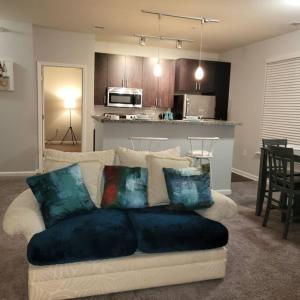 a living room with a couch with pillows on it at Stylish and Spacious, close to the Hospital. in Fort Wayne