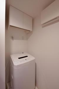 una lavatrice e asciugatrice bianche in una piccola cucina di Hostel Inn Tokyo Asakusa East a Tokyo