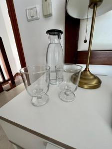 três copos vazios sentados numa mesa com um candeeiro em Casa La Asomada El Hierro em Las Casas