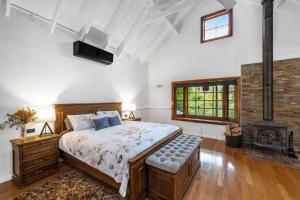 a bedroom with a large bed and a fireplace at Twin Peaks in Kangaroo Valley