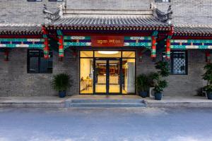 an entrance to a building with a yellow door at Happy Dragon Hotel -- Nearby Tiananmen square & Forbidden City & Line 5,6,8 Subway Nearby & Free coffee & Free laundry & Fluent English speaking& Tourist attractions ticket service & Free WiFi unlimited for Western software, Shuttle bus to the Great Wall in Beijing