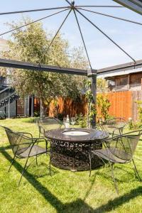 a patio with a table and chairs in the grass at Luxury Victorian House 10 mins to SF, Rose Garden & 3 Private Parking in Oakland