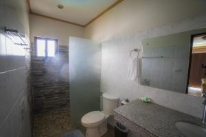 a bathroom with a toilet and a sink and a mirror at Kasagpan in Tagbilaran City +92 photos