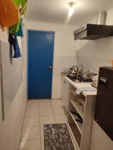 a kitchen with a blue door in a kitchen at Cabaña Pop in San Pedro de Atacama