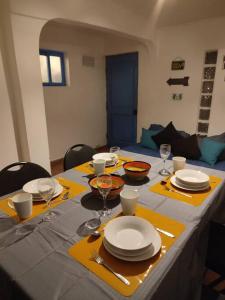 a table with yellow napkins and plates and wine glasses at Cabaña Pop in San Pedro de Atacama