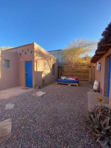 a courtyard of a house with a blue door at Cabaña Pop in San Pedro de Atacama