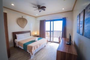 a bedroom with a bed and a balcony at Kasagpan in Tagbilaran City