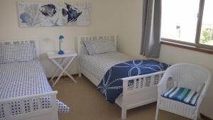 a bedroom with two beds and a table and chairs at Lighthouse Palms in Ulladulla