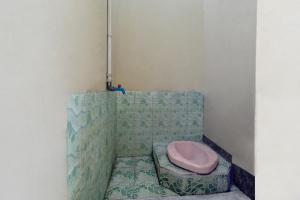 ein Bad mit einem rosa WC in der Ecke in der Unterkunft SPOT ON 92832 Al Mahira Syariah in Majalengka