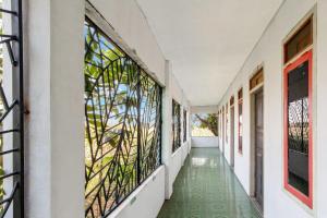 - un couloir d'une maison dotée de parquet vert et de fenêtres dans l'établissement SPOT ON 92832 Al Mahira Syariah, à Majalengka