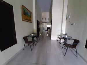 a hallway with two tables and chairs and a television at OYO 92899 Penginapan Laota Syariah in Luwuk