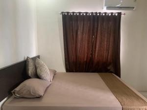 1 cama con cortina marrón en una habitación en OYO 92899 Penginapan Laota Syariah, en Luwuk