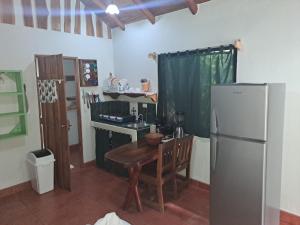 a kitchen with a wooden table and a refrigerator at Casa Rosada Nosara in Nosara