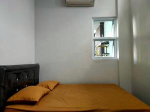 Bett in einem weißen Zimmer mit Fenster in der Unterkunft SPOT ON 92900 Kost 3 Kelor Syariah in Luwuk