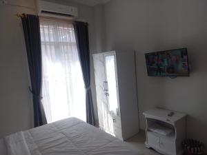a bedroom with a bed and a large window at OYO 92879 Imperial Inn in Cilacap
