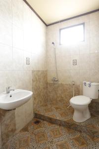 uma casa de banho com um lavatório e um WC em OYO 92865 Guest House Pandita em Sebawang