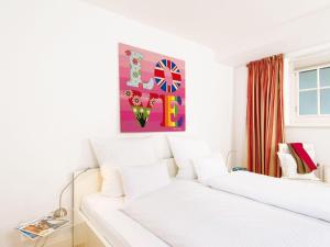 a bedroom with two white beds and a painting on the wall at Kampen-Kliff-3 in Kampen