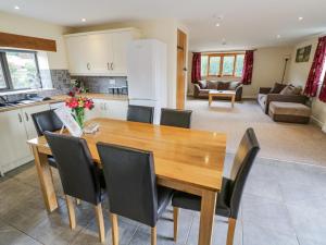 cocina y sala de estar con mesa de madera y sillas en Betty's Barn, en Eaton