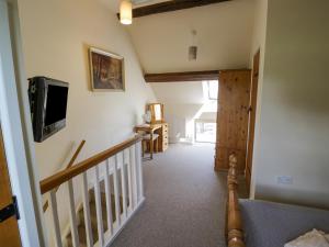 a hallway with a staircase with a tv on the wall at Kite's Nest in Eaton